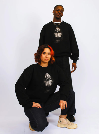 Two models, one male and one female, wearing black jumpers with a front print Icon design.